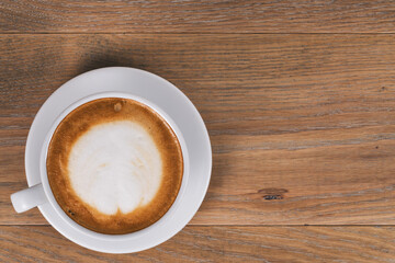 top view of fresh cappuccino on wood oak table