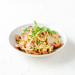 Spaghetti with clams, bacon, and cherry tomatoes in a white wine sauce