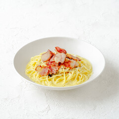 Creamy pasta with crispy bacon in a white bowl