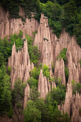Unique Eroded Rock Formations Surrounded by Lush Greenery in Midday Sunlight