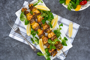 Grilled lamb, yellow peppers and baby potato skewers with green leaf salad