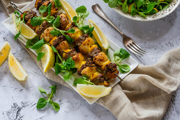 Grilled lamb, yellow peppers and baby potato skewers with green leaf salad