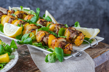 Grilled lamb, yellow peppers and baby potato skewers with green leaf salad