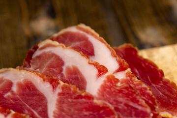 a piece of cured pork ham with thin layers of lard on the table