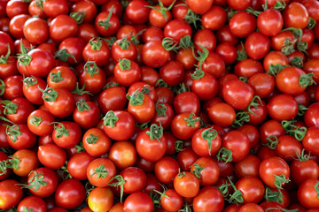 Many small red cherry tomatoes on a counter at a Turkish bazaar