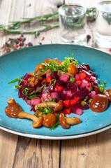 Ukrainian cuisine salad vinaigrette in a blue plate on a wooden background vertical photo