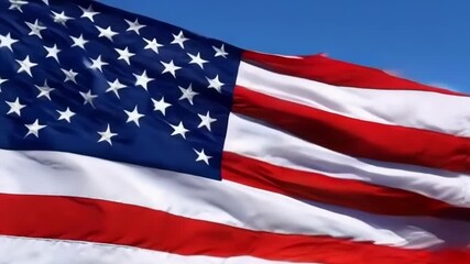 A vibrant American flag waves against a clear sky, capturing themes of patriotism and freedom with dynamic motion