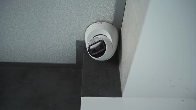 Close up shot of installed surveillance camera hanging on the ceiling in the office building. Innovative monitoring and tracking technologies. CCTV system, security, privacy and database concept.