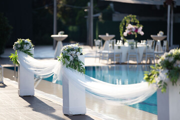 Minimalist Wedding Setup with Poolside View and Floral Arrangements