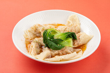 Portion of appetizing asian wonton dumplings with bok choi