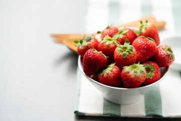 Fresh strawberries in a bowl on wooden table