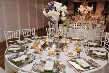 Elegant Wedding Venue with Floral Centerpieces and White Chairs