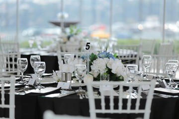 Elegant Wedding Reception Table Setting with White Flowers and Black Tablecloth