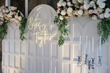 Refined Wedding Cake Presentation with Flowers and Lighting Inside Venue