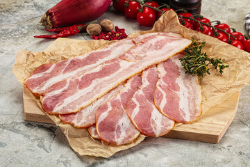 Sliced pork bacon over board
