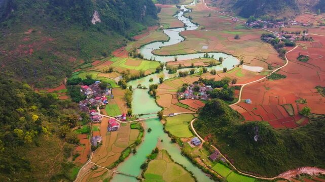 This drone footage captures the breathtaking beauty of Phong Nam Valley in Cao Bang. The video showcases a majestic winding river flowing through lush green rice fields, framed by rugged mountains. 