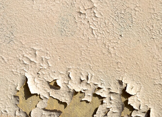 Cracked beige paint on the wall of a house. Abstract background