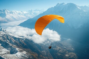 Paraglider flying over majestic mountains and valley on a sunny day