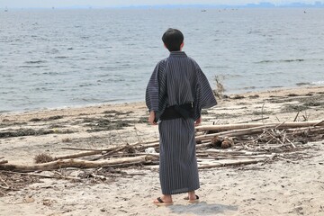 海を見つめる浴衣姿の日本人男性