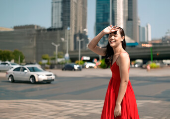asian woman blog sunbeam by hand and wearing dress walking on street