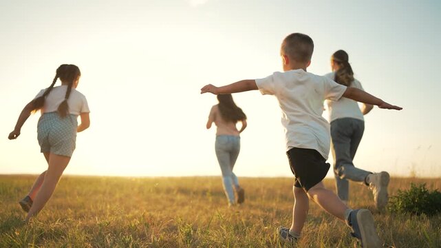 Children running outdoors pretending fly. Kids playing active plane game. children running freely. Imaginary flight nature. Active playtime for children. children as planes. active kids fly outdoors.