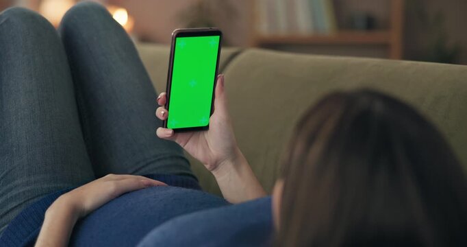 Woman, pregnant and phone green screen on sofa for online shopping, maternity information and research baby care. Expecting mom, mobile chroma key and relax at home with social media or prenatal app