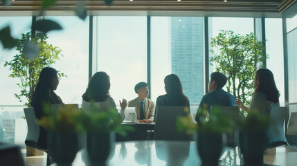 A business meeting is in progress in a modern office, with professionals gathered around a table discussing ideas, large windows letting in natural light.