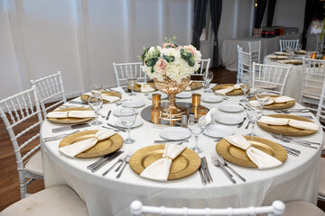Elegant round wedding table with gold accents and floral centerpiece