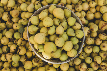 Yellow pears in a basket on the counter of a farmers market.