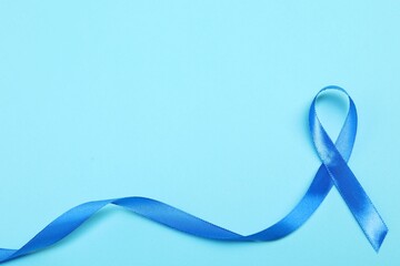 Blue ribbon on color background, top view with space for text. Prostate cancer awareness