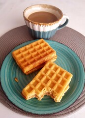 Breakfast with coffee and waffles on the table. Selective focus.