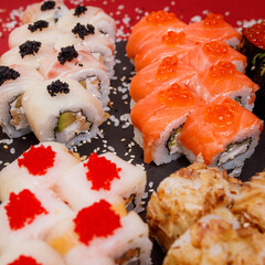 delicious set of rolls featuring tasty Philadelphia cheese with shrimp and salmon, a delightful baked roll, and two appetizing rolls with red and black caviar on a beautiful red background