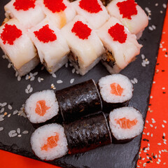 delicious set of rolls featuring fresh maki with salmon and an appetizing roll with red caviar and Philadelphia cheese on a beautiful red background