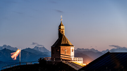 Wallberg Kircherl mit Fahne im Wind und Bergen