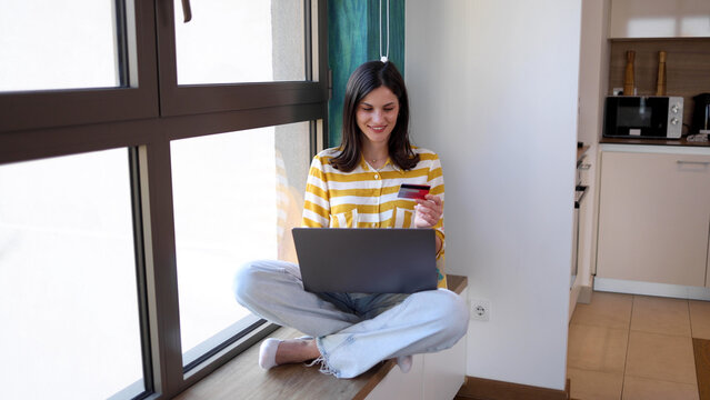 Beautiful woman using laptop and shopping online at home