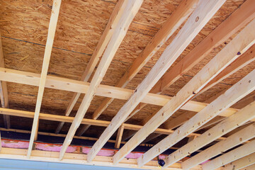During construction of new home, wooden frame beams are used to frame roofing trusses