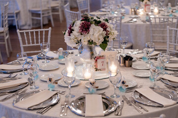 eautiful wedding table decor with white tablecloth and silver chargers