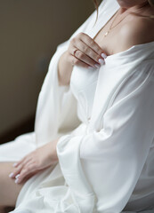 The bride in a white robe. Morning of the bride. Preparation for the wedding.