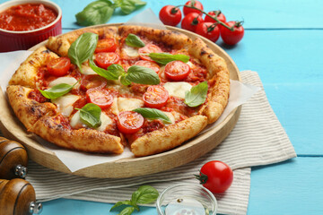 Delicious Margherita pizza and ingredients on light blue wooden table