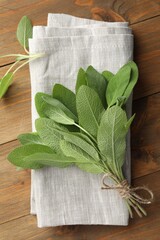 Bunch of green sage leaves on wooden table, top view