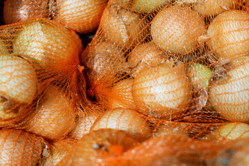 Onions in orange mesh bags