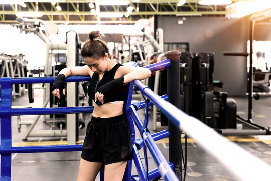 tired woman fall punching ring corner. exhausted female boxing person stagger to turnbuckle rest a bit while training. determined fitness woman fatigued at boxing fight muscle training on the ring