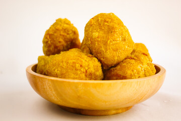 Tahu goreng cripsy, or crispy fried tofu, is one type of snack in Indonesia on wood plate isolated on white background. Perfect for recipe, article, catalogue, commercial, or any cooking contents
