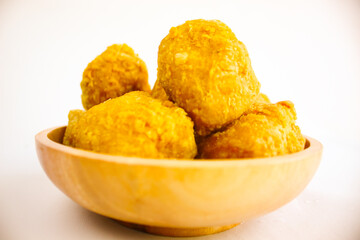 Tahu goreng cripsy, or crispy fried tofu, is one type of snack in Indonesia on wood plate isolated on white background. Perfect for recipe, article, catalogue, commercial, or any cooking contents

