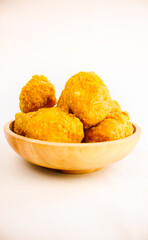 Tahu goreng cripsy, or crispy fried tofu, is one type of snack in Indonesia on wood plate isolated on white background. Perfect for recipe, article, catalogue, commercial, or any cooking contents
