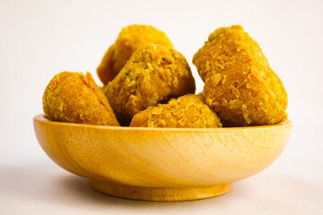 Tahu goreng cripsy, or crispy fried tofu, is one type of snack in Indonesia on wood plate isolated on white background. Perfect for recipe, article, catalogue, commercial, or any cooking contents
