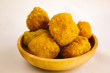 Tahu goreng cripsy, or crispy fried tofu, is one type of snack in Indonesia on wood plate isolated on white background. Perfect for recipe, article, catalogue, commercial, or any cooking contents
