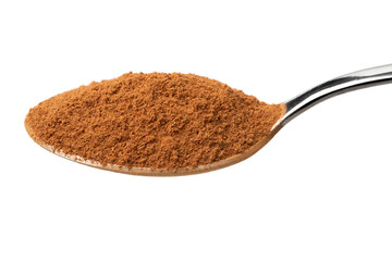Metal spoon with ground cinnamon on white background close up