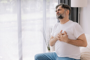 Pain on heart, heart attack. Unhappy middle aged senior man suffering from chest pain heart attack...