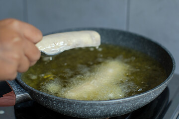Put banana with flour in pan with hot oil. Banana deep fried is a popular street food in Indonesia